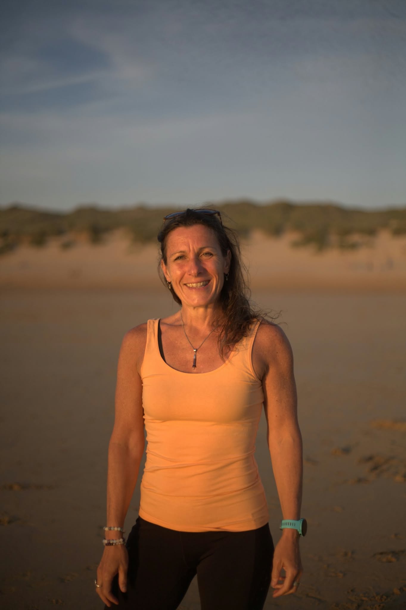Lisa Picton smiling on the beach at sunset