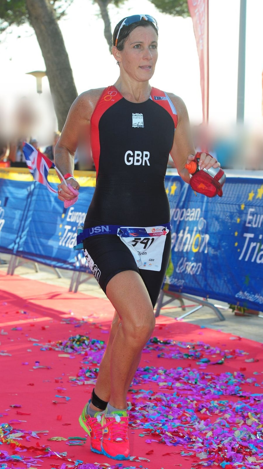 Lisa racing for Great Britain at the European Triathlon Union age-group championships, carrying a Union Jack