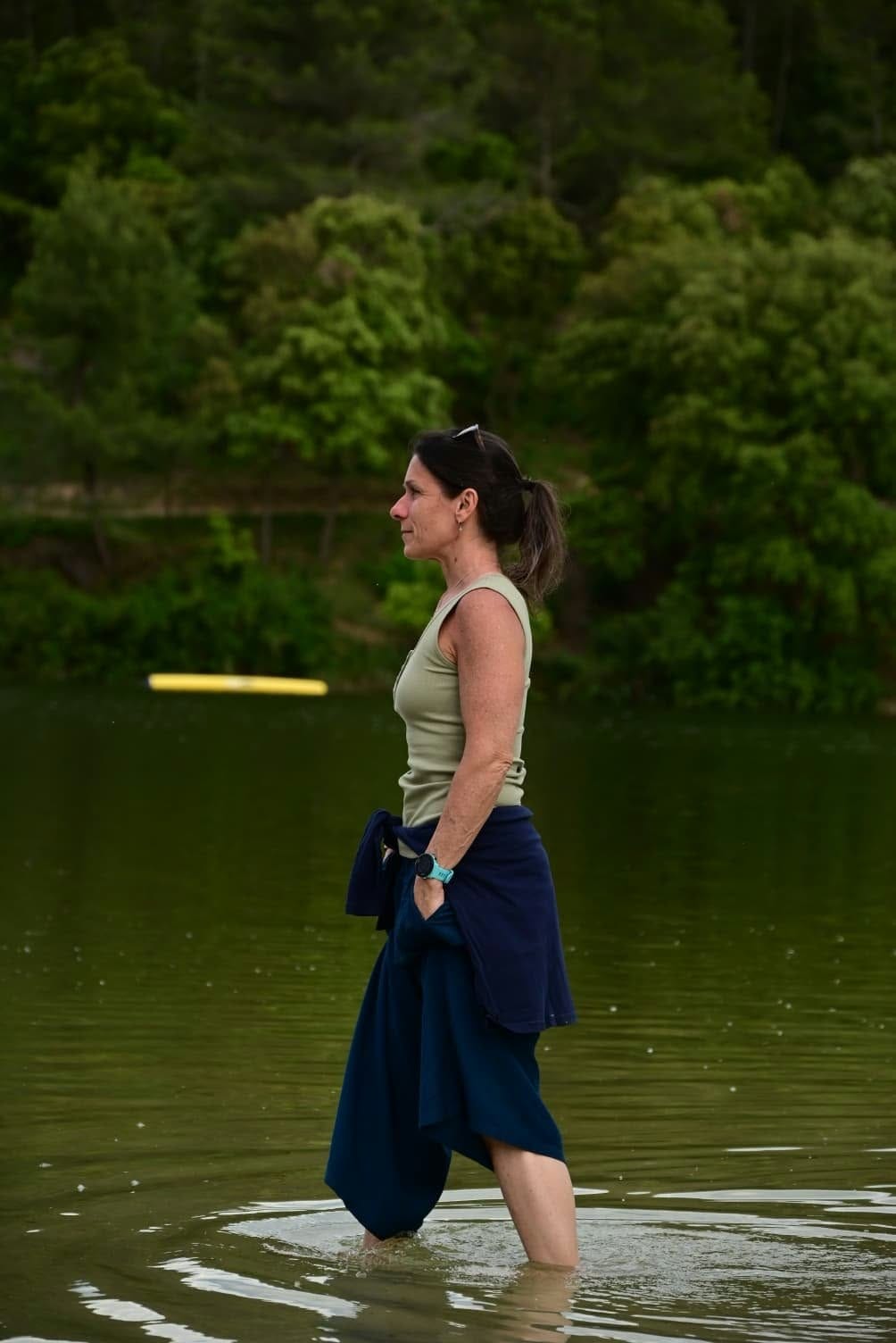 Lisa standing calmly in a lake, looking out across the water